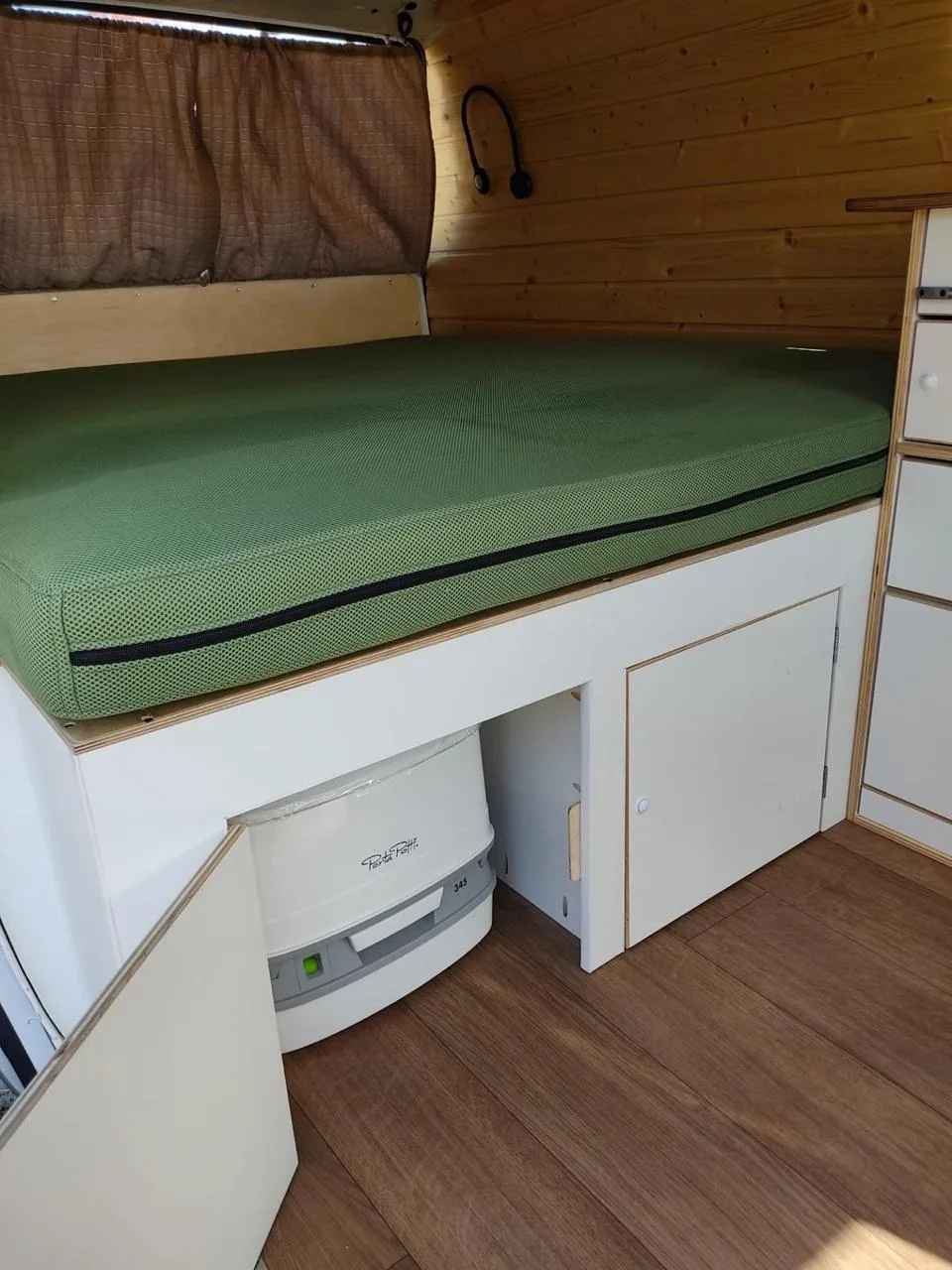 Bed detail with dry chemical toilet hidden in a compartment under the platform