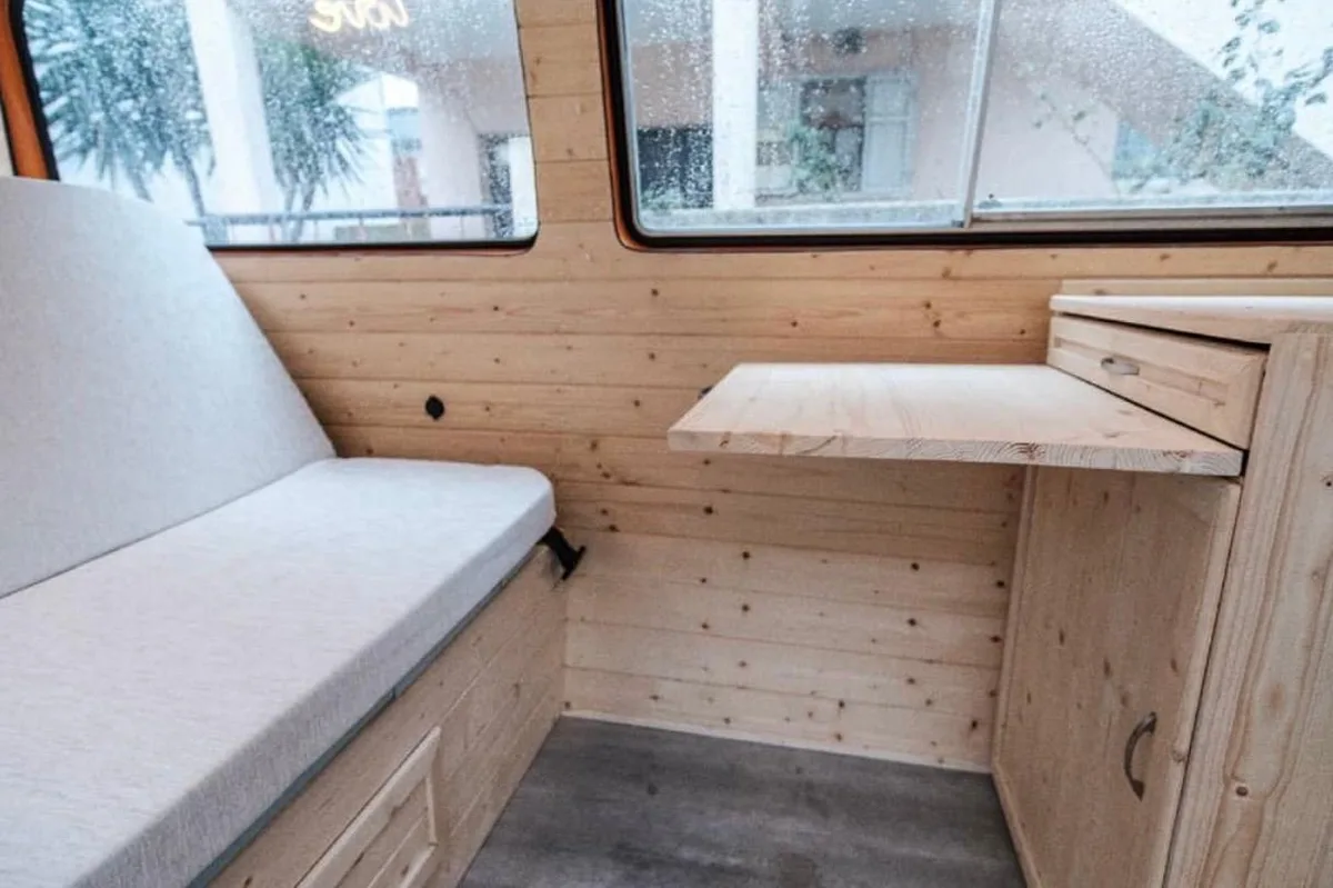 View of the bench seat and fold-out table with the wide windows