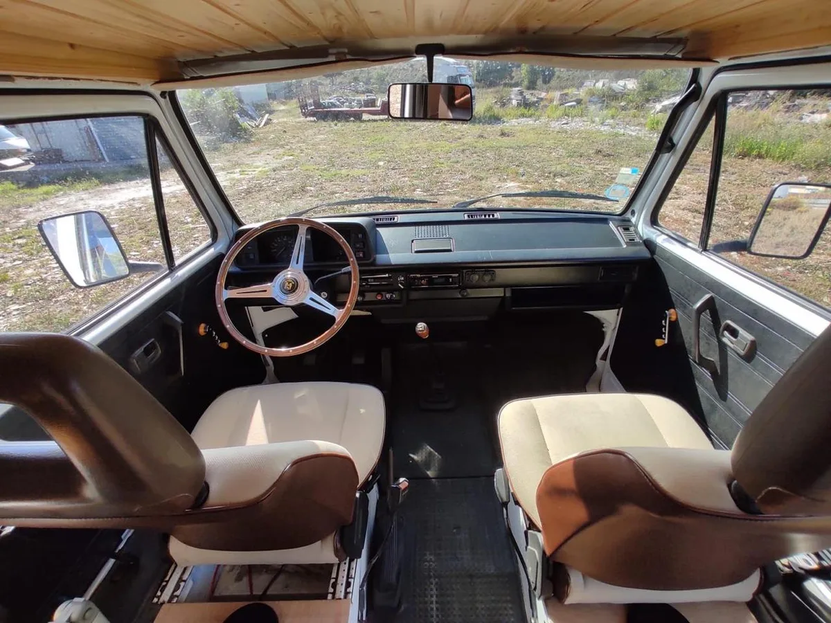 Restored cabin with a classic wooden steering wheel and brown-cream seats