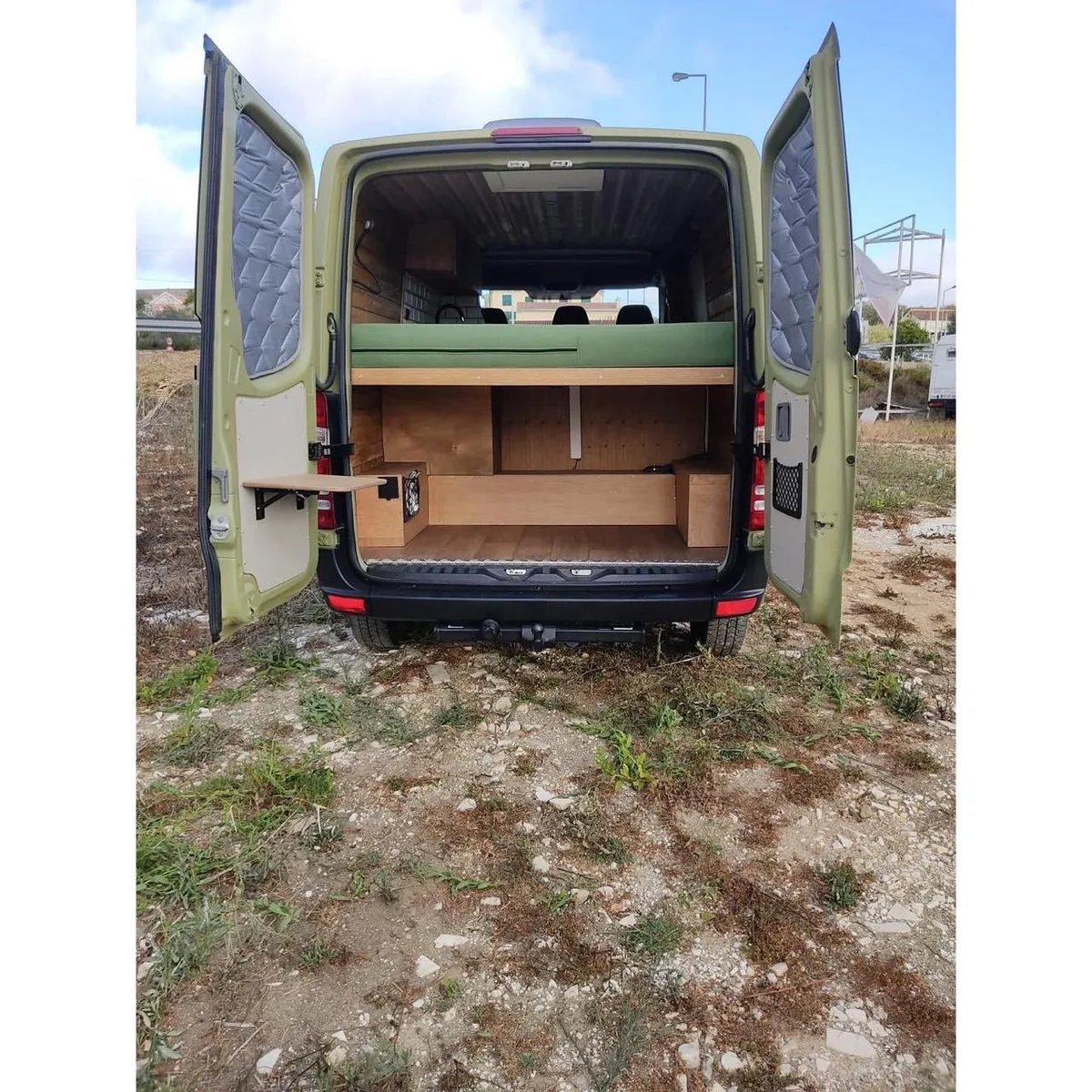 Rear view with open doors — lower garage and elevated bed