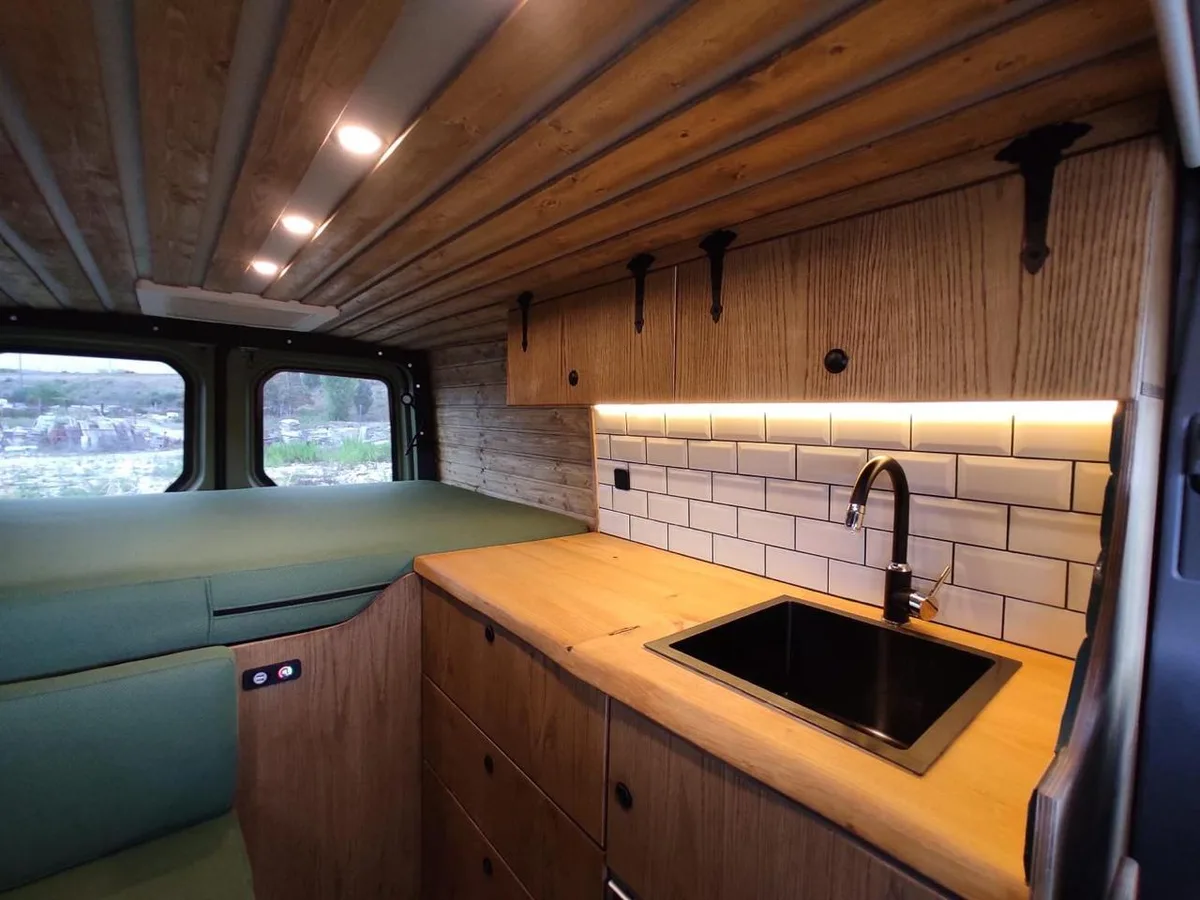 Full interior with LED lighting — bed and oak/pine kitchen