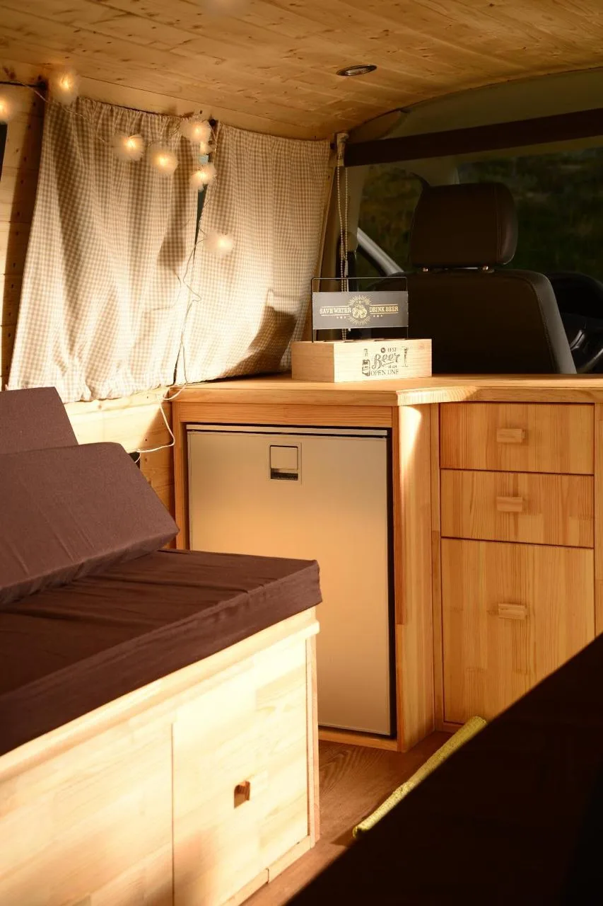 Detail — built-in compressor fridge and wooden drawers